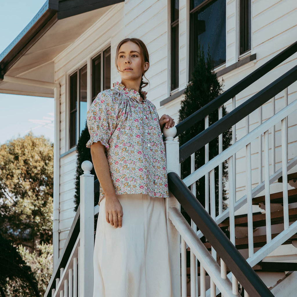 Woman standing on a staircase in front of a house