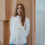 White linen shirt with pintucked bib front, lace trim and puff sleeves, styled with blue jeans — Ada White Linen Shirt by Sorority