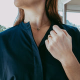 Person wearing a dark blue shirt with a blurred outdoor background