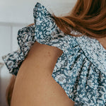 Close-up of a person wearing a floral dress with a blurred background