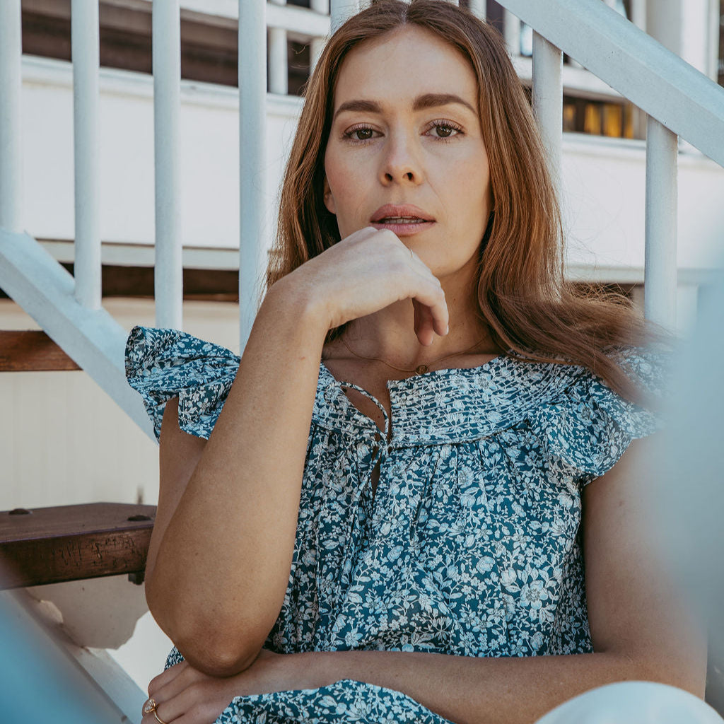 Woman in a floral dress sitting on a staircase