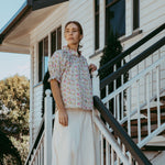 Woman standing on a staircase in front of a house