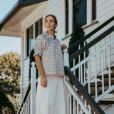 Woman standing on a staircase in front of a house