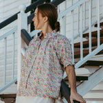 Woman in a floral blouse standing on a staircase