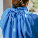 Person wearing a blue dress with a blurred background