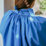 Person wearing a blue dress with a blurred background