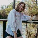 Woman standing outdoors with trees in the background