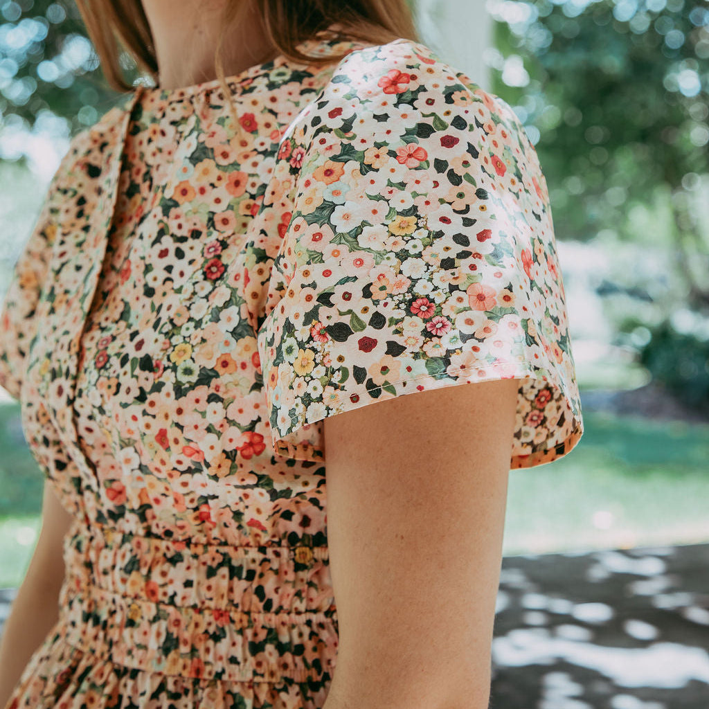 Woman wearing a floral dress with a blurred outdoor background