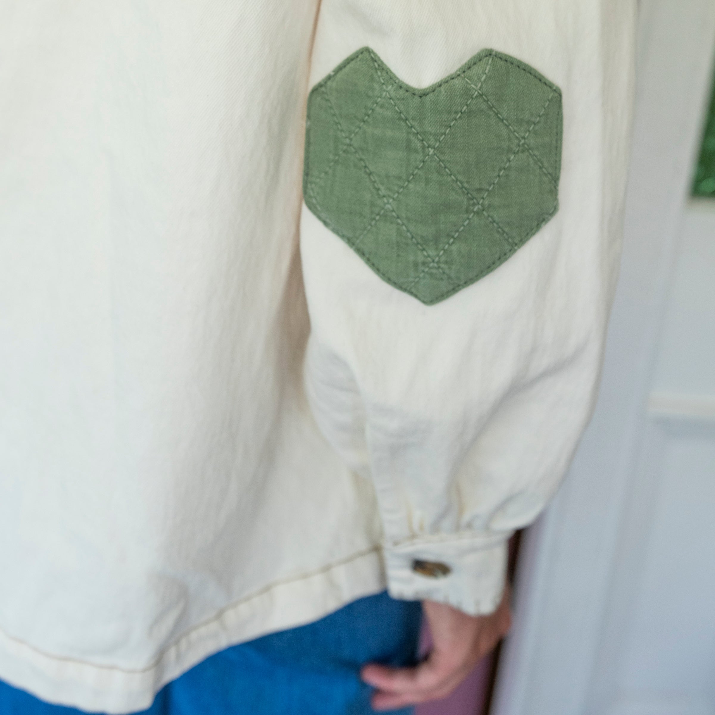 close up of quilted patchwork elbows on cream coloured denim jacket