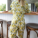 Close up of belted yellow rose pants in a lightweight cotton fabric with matching floral puff sleeve top by Liberty 