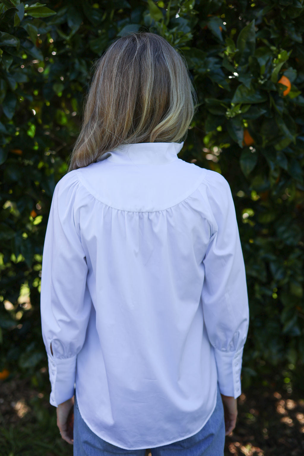 Model wearing Iris cotton blouse, back view