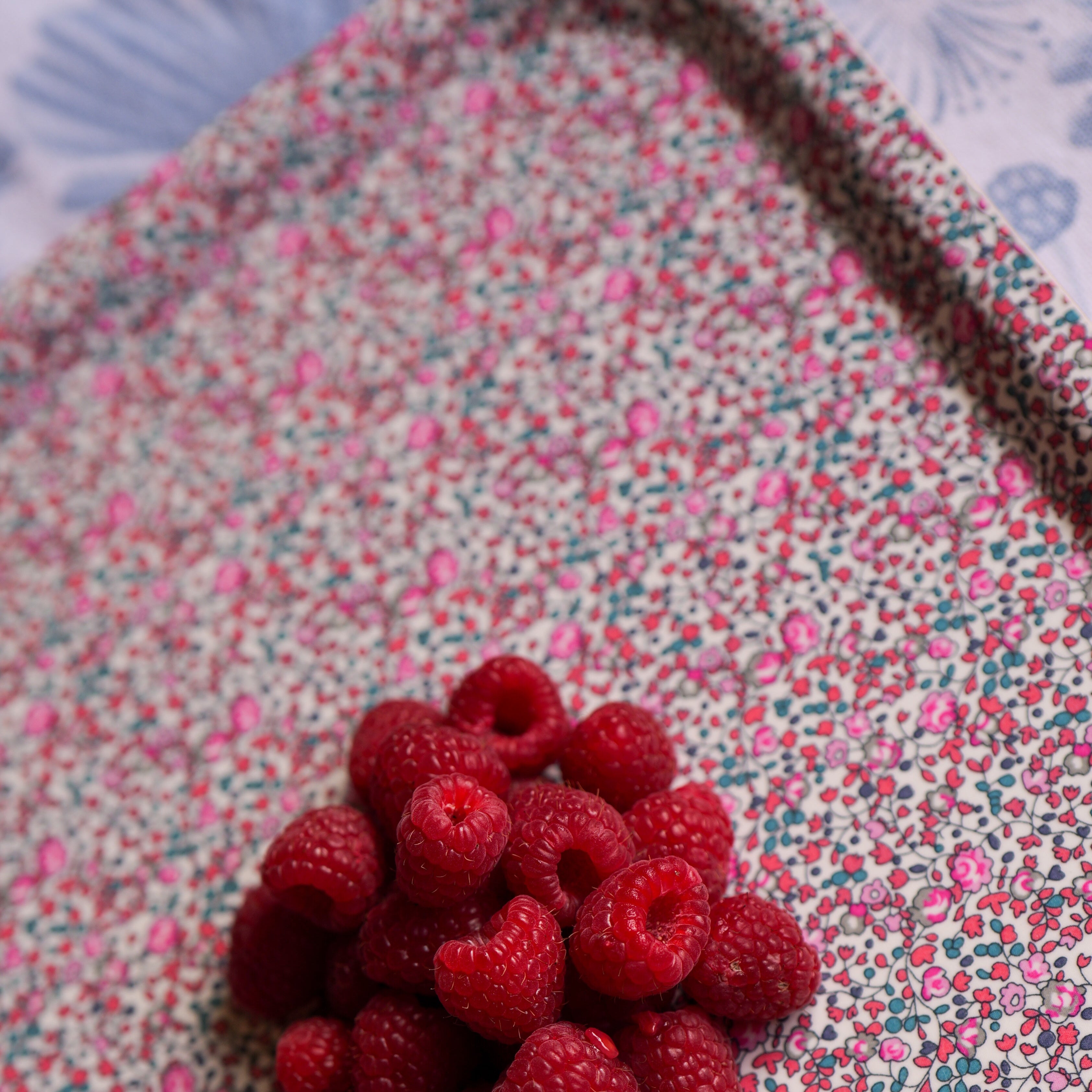 Red berries on a floral fabric background Liberty Eloise