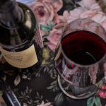 Wine bottle and glass on a floral tablecloth