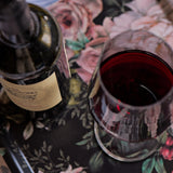 Wine bottle and glass on a floral tablecloth