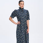 Woman wearing a dark blue floral dress on a white background