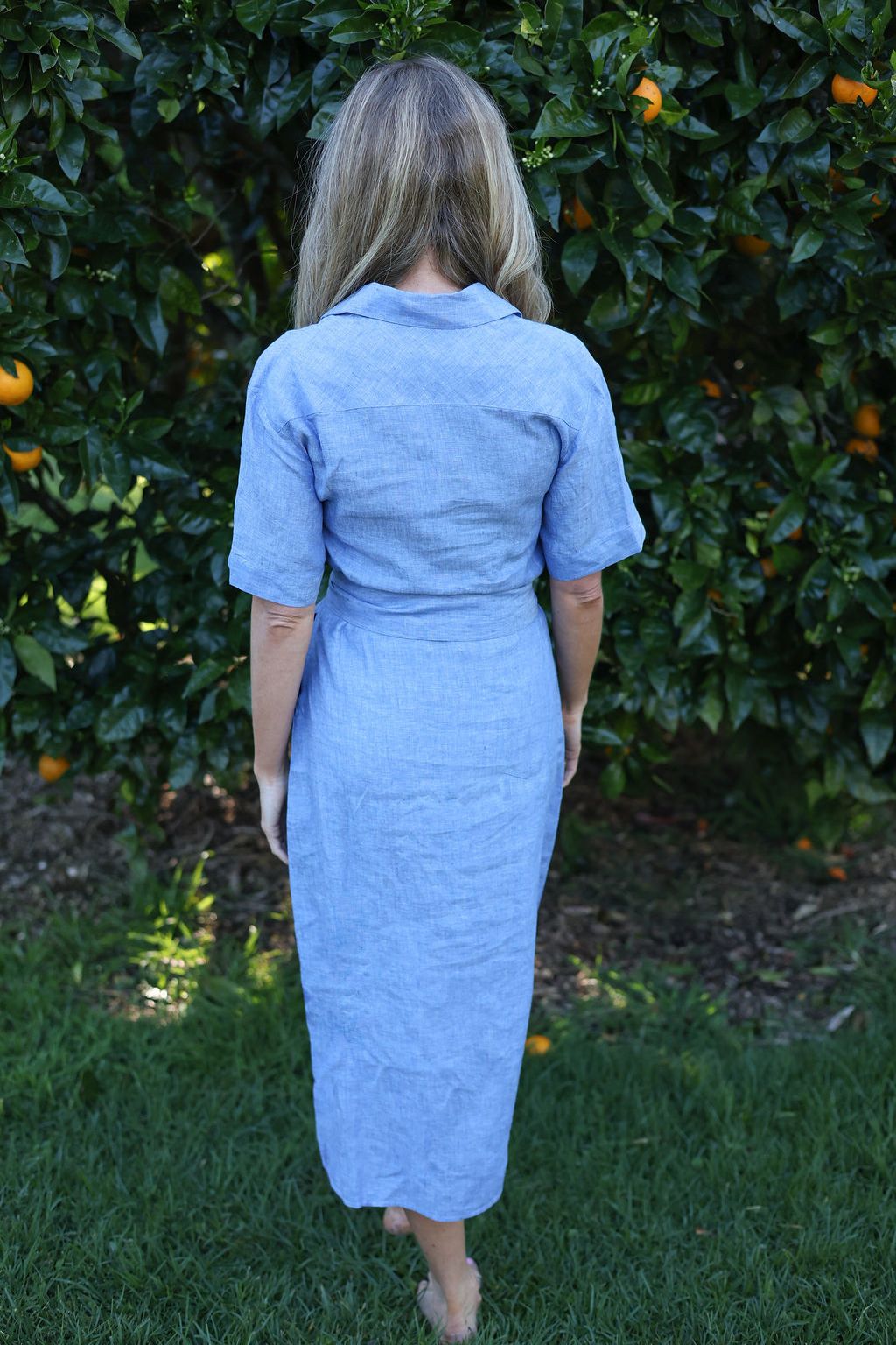 model wearing blue Cybil linen shirt dress, back view