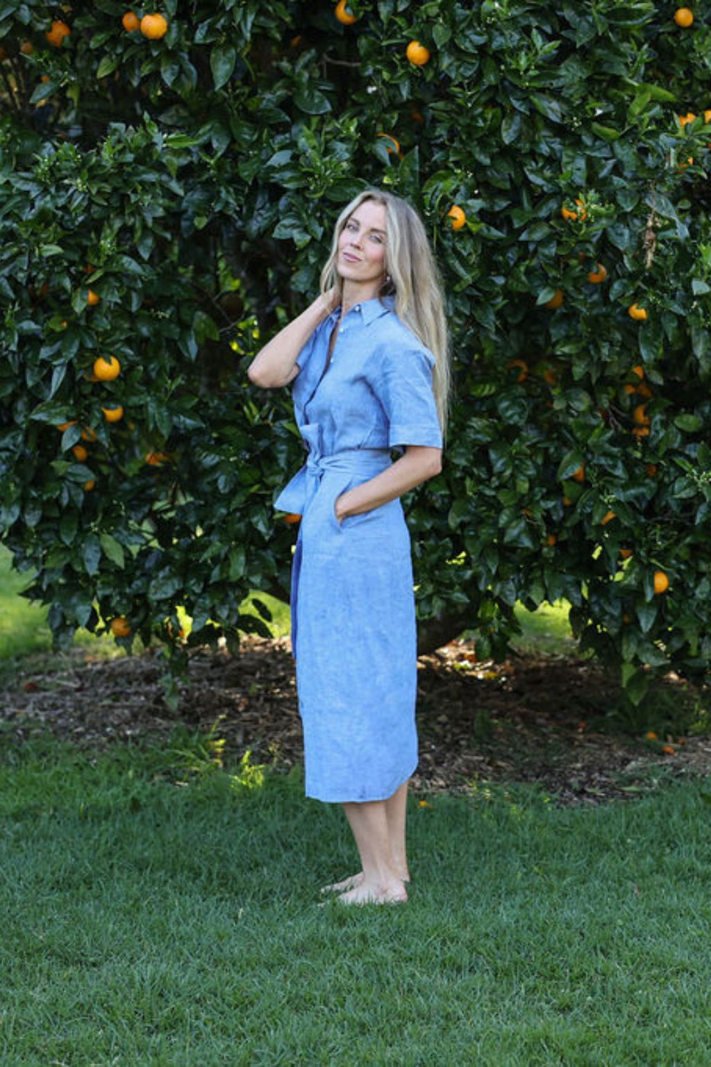 model wearing blue Cybil linen shirt dress, side view, full length
