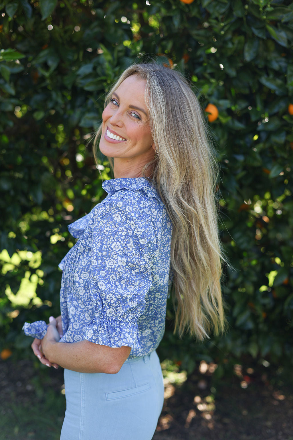 model wearing Nina shirt, cotton, in Wharfdale Liberty print, side view