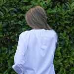 model wearing Valerie white cotton shirt with lace trim, back view